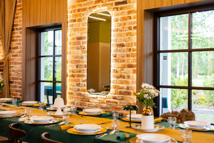 Wnętrze restauracji z dużymi oknami i ścianą z płytek ceglanych z cegły rozbiórkowej.