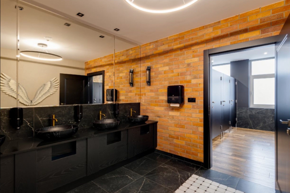 Ściana z płytek z cegły rozbiórkowej w nowoczesnej toalecie komercyjnej